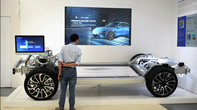 Un visiteur regarde un châssis de véhicule dans une salle d'exposition au siège du fabricant chinois de batteries pour véhicules électriques CATL (Contemporary Amperex Technology Co., Limited) à Ningde, dans la province de Fujian, au sud-est de la Chine.